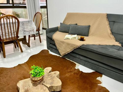 a living room with a couch and a table at Apto Vida Boa 2 - 250m do mar in Palhoça