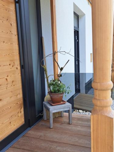 a potted plant sitting on a bench on a porch at Ferienhaus & -wohnung Flatscher in Waidring