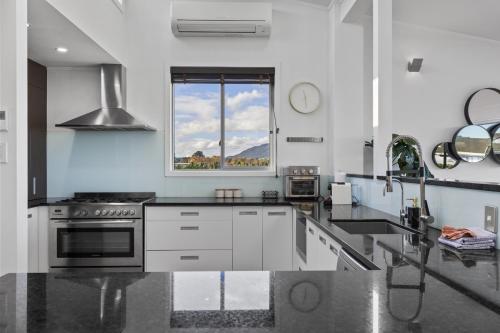 a kitchen with white appliances and a window at Sanctuary 53 Beautiful Views in Taupo
