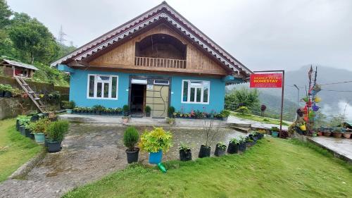 a blue house with potted plants in front of it at Orange Villa in Rinchingpong