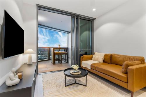 a living room with a couch and a table at Luxurious 2 Bed Apartment with Pool, Sauna & Gym in Brisbane