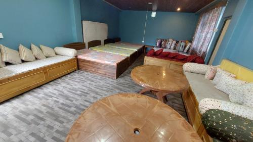 a room with two beds and a couch and a table at Orange Villa in Rinchingpong
