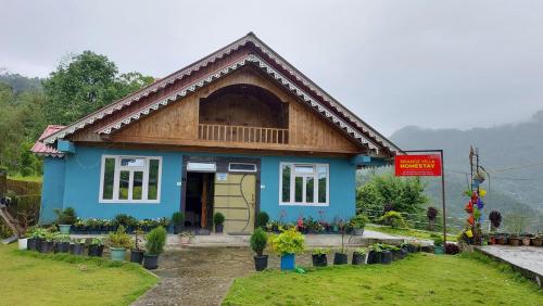 a blue house with a sign in front of it at Orange Villa in Rinchingpong
