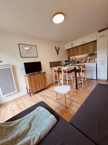 un salon avec une table et une cuisine dans l'établissement Studio Hart 2, aux Gets