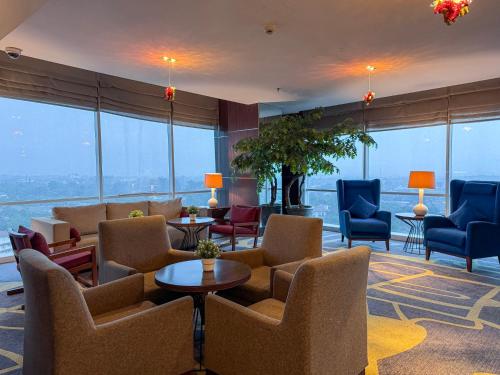 a hotel lobby with chairs and tables and windows at Crowne Plaza Bandung by IHG in Bandung