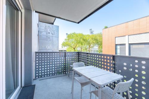 un patio avec une table et des chaises sur un balcon dans l'établissement OIQIA • Bucolie, à Rouen