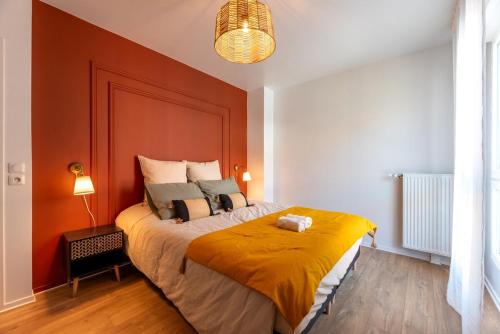 une chambre avec un grand lit aux murs orange dans l'établissement OIQIA • Bucolie, à Rouen