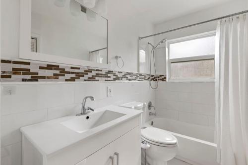 a white bathroom with a sink and a toilet at 2 Bedroom Cozy House Near Barry University in Miami