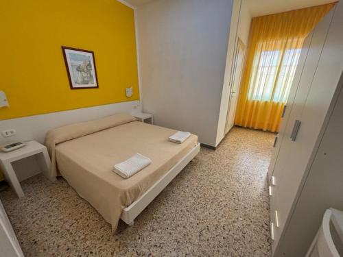 a bedroom with a bed and a yellow wall at Delfino in Marina di Camerota