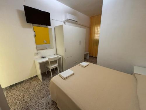 a bedroom with a bed and a desk and a mirror at Delfino in Marina di Camerota