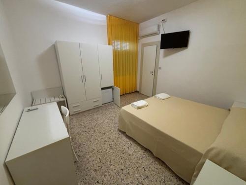 a room with two beds and a desk and cabinets at Delfino in Marina di Camerota