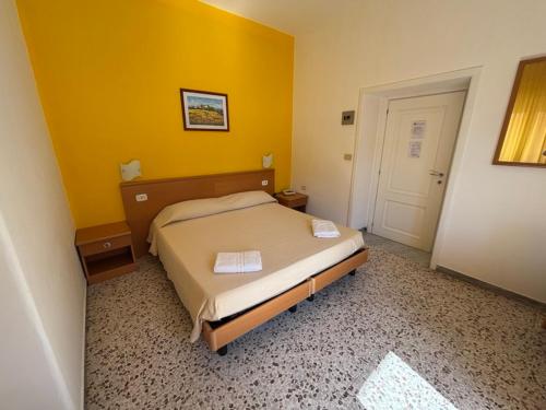 a bedroom with a bed and a yellow wall at Delfino in Marina di Camerota