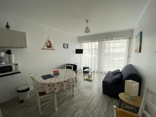 un salon avec une table et un canapé dans l'établissement Les Mouettes, à Les Sables-dʼOlonne