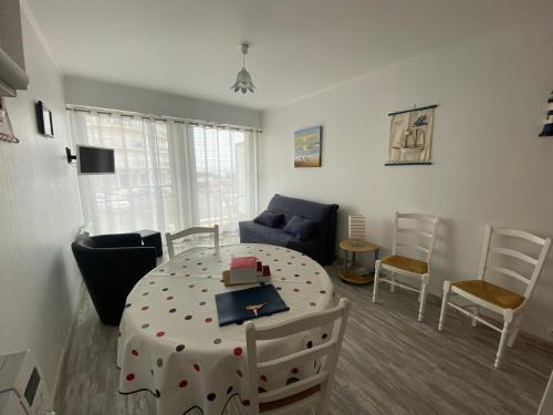 une pièce avec une table, des chaises et un canapé dans l'établissement Les Mouettes, à Les Sables-dʼOlonne