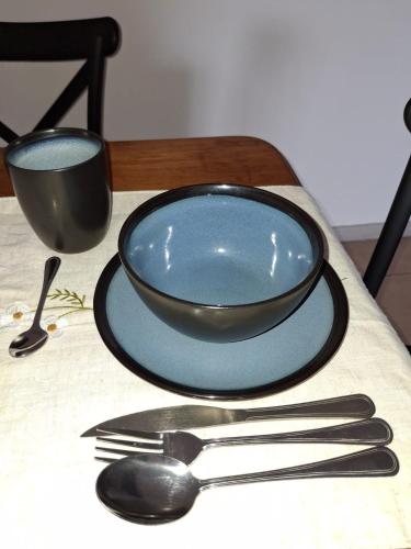 a plate and a bowl and a fork and knife at Departamento comodo a 5 min del Mall IPTV y Calefacción in Maule