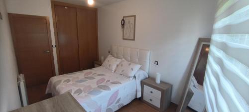 a small bedroom with a bed and a door at Apartamento Muiño Bueu in Bueu