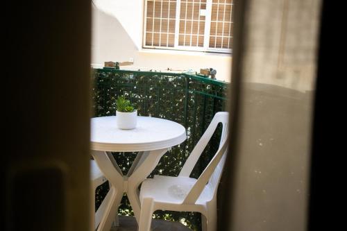 a small table and two white chairs on a balcony at Casa Pirandello in Terracina