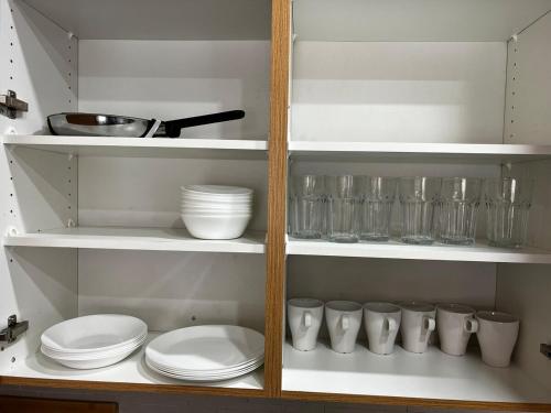a cupboard with plates and bowls and dishes in it at Four Bedroom Spacious House with Parking in Milton, Ontario in Milton