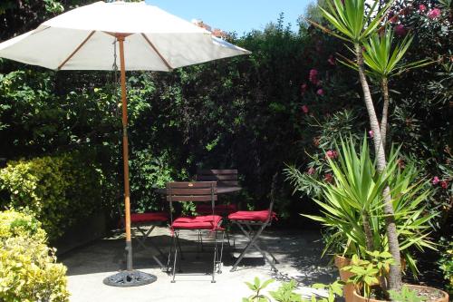 a table and chairs under an umbrella in a garden at Casa de Marlães in Lousada