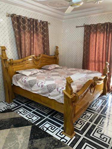 a bedroom with a wooden bed in a room at Dalal Jamu in Serekunda