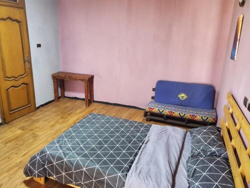 a small room with a bed and a wooden floor at Mad Vervet Backpackers Hostel in Addis Ababa