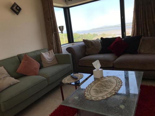 a living room with couches and a glass table at Serene Luxurious Haven with Sea Views Letterkenny Rooms in Letterkenny