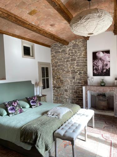 une chambre avec un lit et un mur en pierre dans l'établissement La Maison du Papé, à Monteils