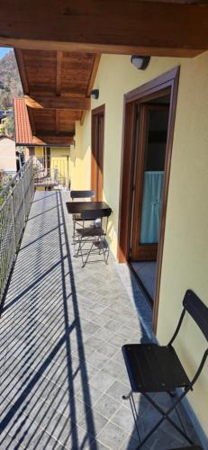 a balcony with chairs and tables on a building at La Mansarda sul lago in Bellano