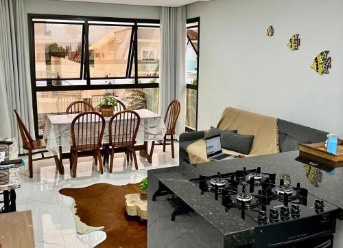 a living room with a table and a dining room at Apto Vida Boa 2 - 250m do mar in Palhoça