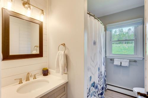 un bagno con un lavandino, uno specchio e una finestra di 8 Mi to Jay Peak Resort Scenic Retreat with Deck a North Troy