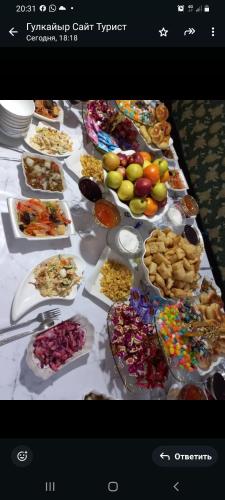 a table filled with lots of different types of food at SALKYN YURT guest house in Kyzart