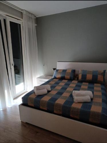 a bedroom with a bed with two towels on it at Appartamento tranquillo Ellis Home in Morbegno