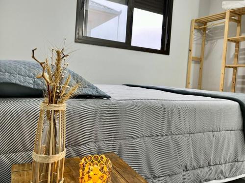 a vase on a table next to a bed at Apto Vida Boa 2 - 250m do mar in Palhoça