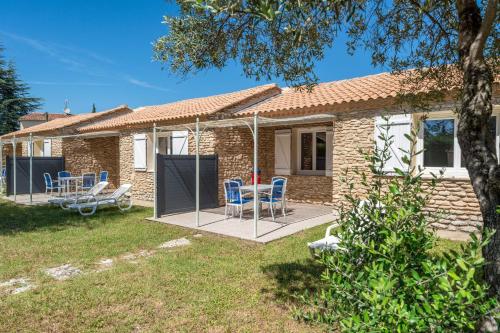 une maison avec une terrasse munie de chaises dans l'établissement Provencal house with garden access, à La Roque-sur-Pernes
