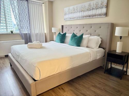 a bedroom with a large white bed with blue pillows at Downtown! 2BD City view Onsite Parking King LM809 in Atlanta