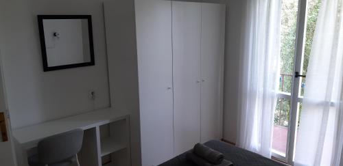 a white room with a window and a mirror at Oleander Apartments in Selce