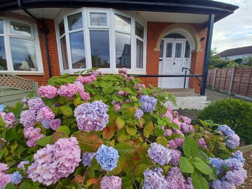 a house with a bunch of flowers in front of it at Heysham Seaside Hideaway in Heysham