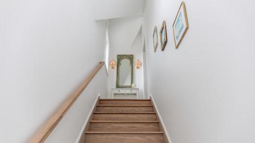 a staircase in a home with white walls and wooden floors at The Ocean Loft At Kings in Cape May