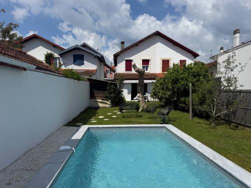 une piscine dans l'arrière-cour d'une maison dans l'établissement Maison Piscine Jardin Parking, à Biarritz