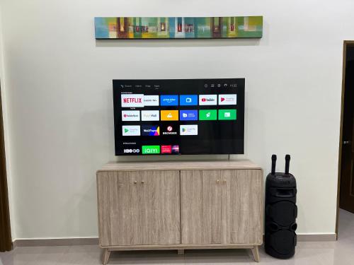 a flat screen tv sitting on top of a wooden cabinet at KLIA HBO Villa Homestay in Nilai