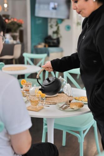 a woman standing over a table with food on it at Hotel Boutique Trinidad in Viña del Mar