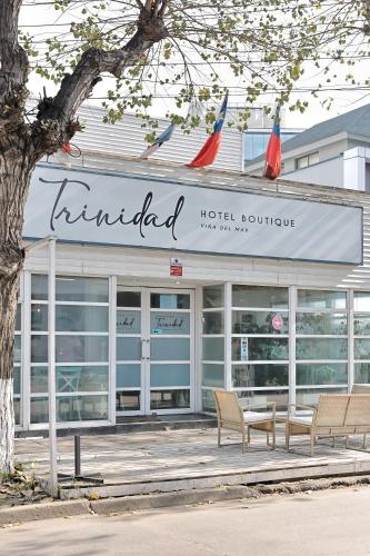 a hotel rooftop with two chairs in front of a building at Hotel Boutique Trinidad in Viña del Mar