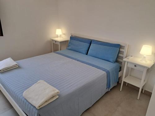 a bedroom with a blue bed and two night stands at Agriturismo Tenuta La Siesta in Gallipoli