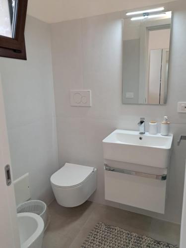 a white bathroom with a toilet and a sink at Agriturismo Tenuta La Siesta in Gallipoli