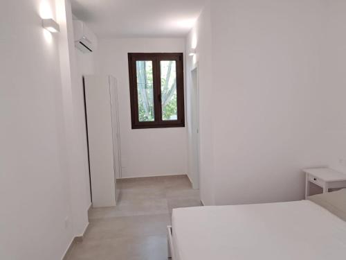 a white room with a bed and a window at Agriturismo Tenuta La Siesta in Gallipoli