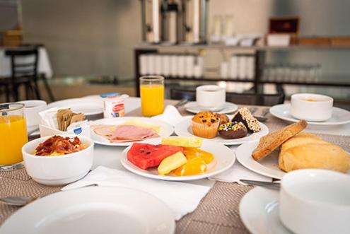 a table topped with plates of food and orange juice at MR Express (ex Hotel Neruda Express) in Santiago