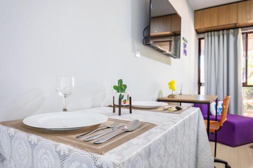 a table with a white table cloth on it at Estúdio aconchegante e funcional - cama casal ou 2 de solteiro - ar condicionado - wifi - netflix - cozinha in Brasilia