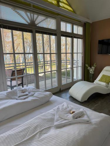 a bedroom with two beds and large windows at Strandresidenz Villa Verdi in Kühlungsborn