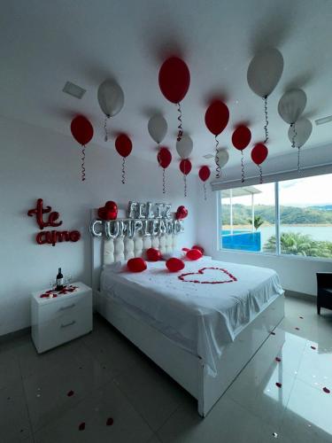 a room with a bed with red balloons on the wall at Hotel Blue Palace in Calima