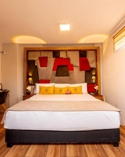 a bedroom with a large bed with yellow and red pillows at Montreal Magdalena Del Mar Hotel in Lima